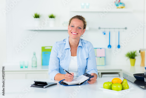 Photo: hausfrau schreibt etwas in den kalender hausfrau schreibt etwas in den kalender