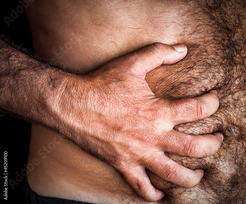 Photo: Man suffering from severe abdominal pain Man suffering from severe abdominal pain