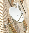Satellite dish mounted on a brick wall
