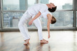 Male Yoga Instructor Assisting Woman