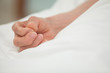 Hand in white bed cover