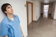 Distressed nurse leaning on wall