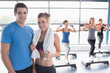 Woman and trainer smiling together in front of aerobics class