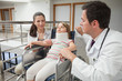 Photo: Mother and doctor crouch next to child in wheelchair Mother and doctor crouch next to child in wheelchair