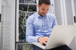 Man using laptop to check servers