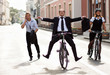 Businessmen and woman running and riding a bike