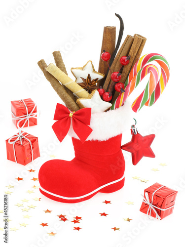 Photo: Sweet Christmas. Santa Claus boot stuffed with candies Sweet Christmas. Santa Claus boot stuffed with candies