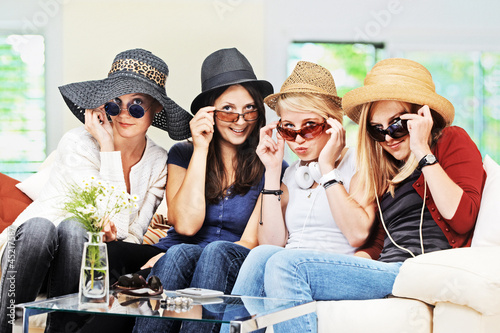 Photo: 4 girls with straw hats and sunglasses on the sofa 4 girls with straw hats and sunglasses on the sofa