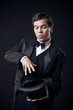 Foto: magician showing tricks with top hat isolated on dark background magician showing tricks with top hat isolated on dark background