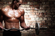 Young guy with muscular body with barbell