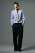 Businessman in suit stands with confidence on gray