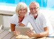 Different aged couple using a tablet pc outside