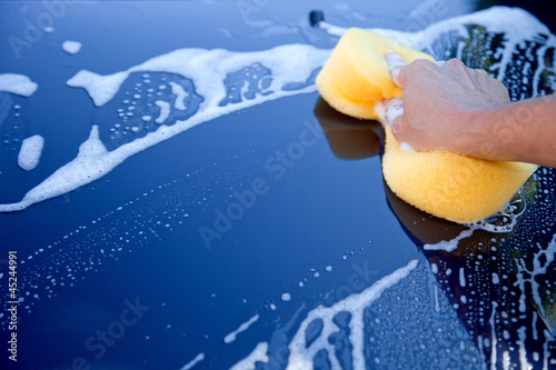 Photo: hand hold sponge over the car for washing hand hold sponge over the car for washing