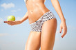 Woman perfect slim body holding an apple.