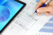 Photo: Tablet Computer with Hand Blue Pen Figures and Graphs Tablet Computer with Hand Blue Pen Figures and Graphs