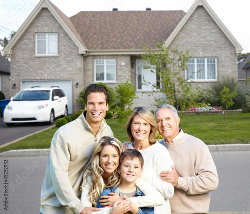 Photo: Happy family near new house. Happy family near new house.