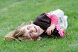 young happy child girl relaxing on green grass