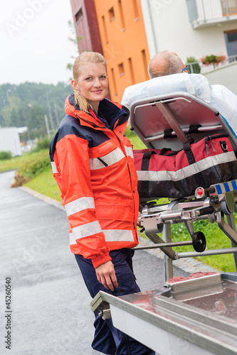 Photo: Patient on stretcher with paramedic emergency aid Patient on stretcher with paramedic emergency aid