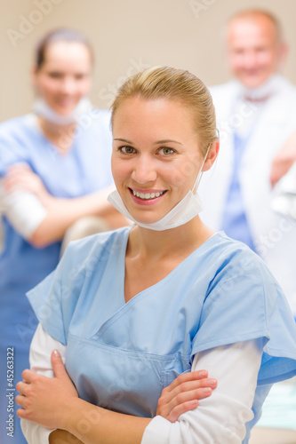 Photo: Smiling female dentist surgeon with colleagues Smiling female dentist surgeon with colleagues
