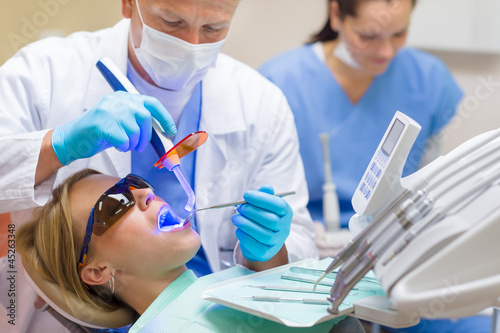 Photo: Dentist use UV lamp female patient Dentist use UV lamp female patient