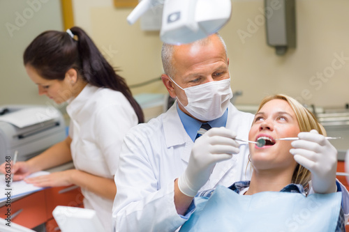 Photo: Dentist doing procedure on young patient woman Dentist doing procedure on young patient woman