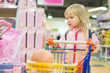 Photo: Adorable girl with small shopping cart in kids mall Adorable girl with small shopping cart in kids mall