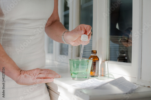 Photo: Health issues, old woman taking prescription drugs and drinking Health issues, old woman taking prescription drugs and drinking