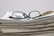 Zeitungen mit Brille