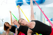 Aerobics pilates women with rubber bands in a row