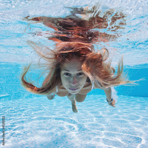 Photo: Underwater woman portrait with white dress in swimming pool. Underwater woman portrait with white dress in swimming pool.