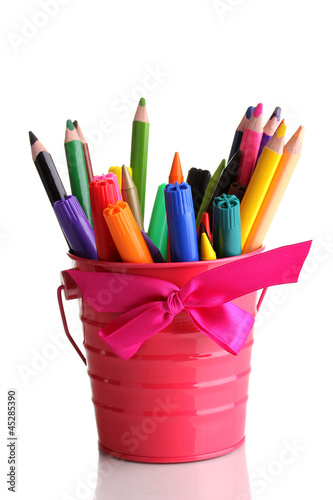 Photo: Colorful pencils and felt-tip pens in pink pail isolated Colorful pencils and felt-tip pens in pink pail isolated