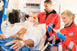 Sick patient with paramedic in ambulance treatment