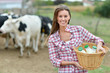 Smiling young farmer carrying bottles of fresh milk