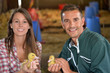 Cheerful couple of duck breeders holding baby ducks