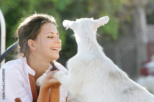 Photo: outdoor portrait of young happy woman with goat outdoor portrait of young happy woman with goat