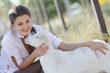 outdoor portrait of young happy woman with goat