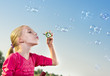 Photo: Girl making soap bubbles outside Girl making soap bubbles outside