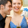 Cheerful amorous couple with gifts, indoors