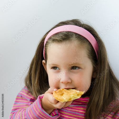 Photo: Pretty little girl eats a pancake for breakfast Pretty little girl eats a pancake for breakfast