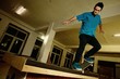 Young man performing a stunt in a skatepark
