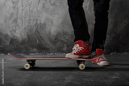Photo: Legs in sneakers on a skateboard Legs in sneakers on a skateboard