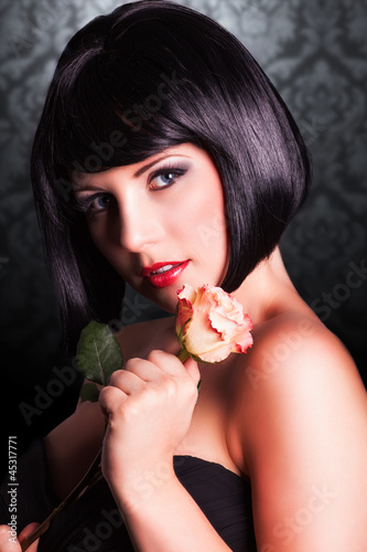 Photo: attraktive schwarzhaarige Frau mit Rose attraktive schwarzhaarige Frau mit Rose