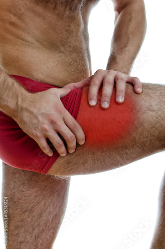 Photo: Male hands holding his leg with muscular pain. Male hands holding his leg with muscular pain.