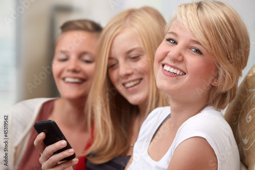 Photo: 3 girls with smartphone on the sofa 3 girls with smartphone on the sofa