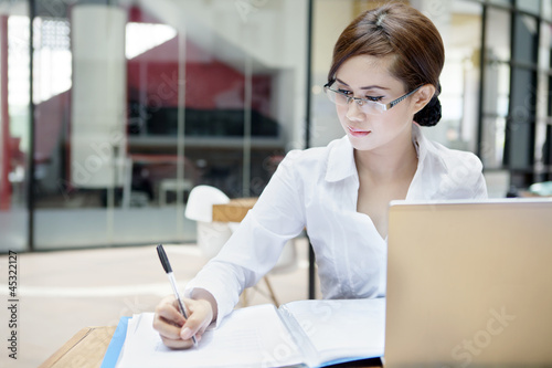 Photo: Businesswoman writes on a document Businesswoman writes on a document