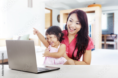 Photo: Cheerful family with laptop computer Cheerful family with laptop computer