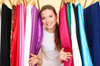 Photo: beautiful young woman near rack with hangers beautiful young woman near rack with hangers