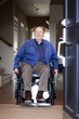 Elderly man in wheelchair at his front door