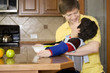 Foto: Father helping disabled son with work in the kitchen Father helping disabled son with work in the kitchen