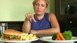 Hungry women looking two plate and choosing one of them